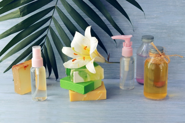 Zeep, spray, leliebloem, glazen flessen met aromatische olie op een houten tafel, spa, natuurlijke cosmetica