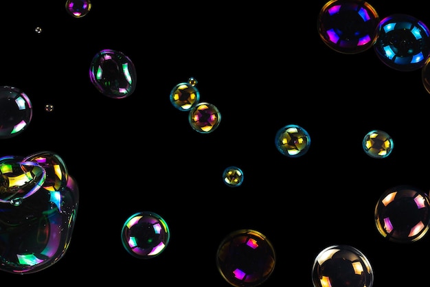 Zeepbellen geïsoleerd op een zwarte achtergrond Ruimte kopiëren