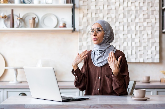 Zeer heet thuis gebroken airconditioner jonge vrouw in hijab die thuis voor laptop zit en