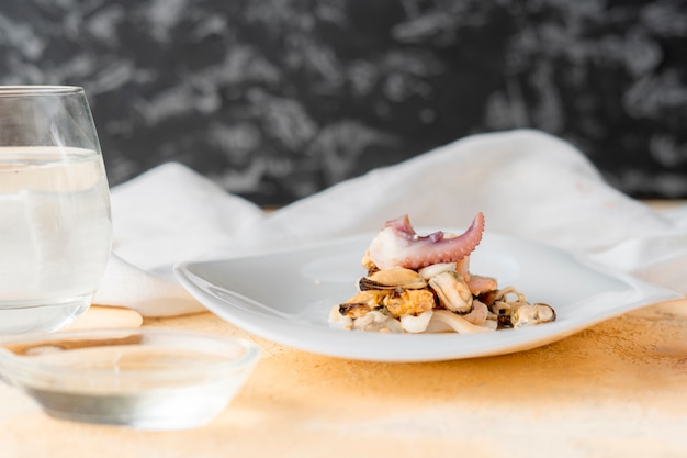 Zeer kleine portie van zeevruchten op een witte plaat in de restaurants