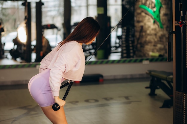 Foto zeer mooi meisje traint haar rug op de sportschool