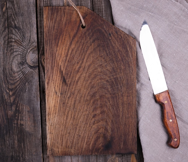 Zeer oude lege houten rechthoekige snijplank en mes, bovenaanzicht