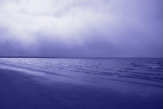 Zeer peritoned zeestrand Noordzee Stormachtig weer sterke golven sombere lucht zeeschuim