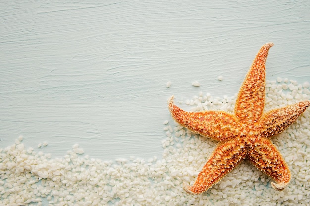 Zeesterre en zand op blauwe houten achtergrond Kopieer ruimte voor de tekst Zomervakantie concept