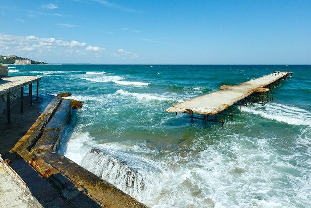 Zeestorm en verwoeste pier met meeuwen op hem