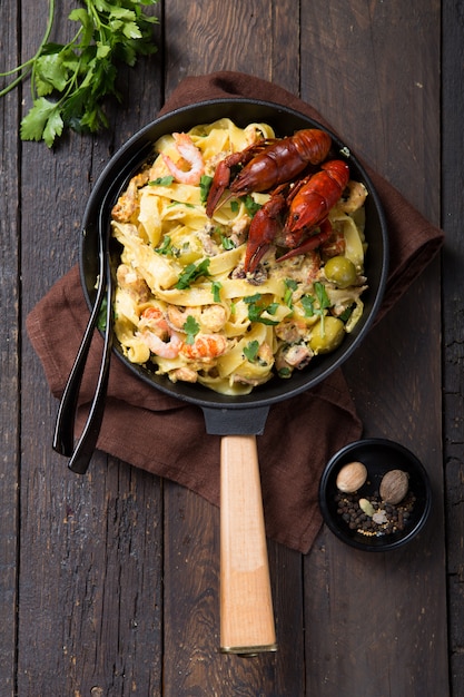 Zeevruchten fettuccine pasta met rivierkreeftjes, octopus shrims, op stenen pan. Gastronomisch gerecht