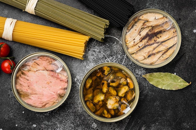 Zeevruchten ingeblikte vis mosselen eten set, op zwarte donkere stenen tafel achtergrond, bovenaanzicht plat lag