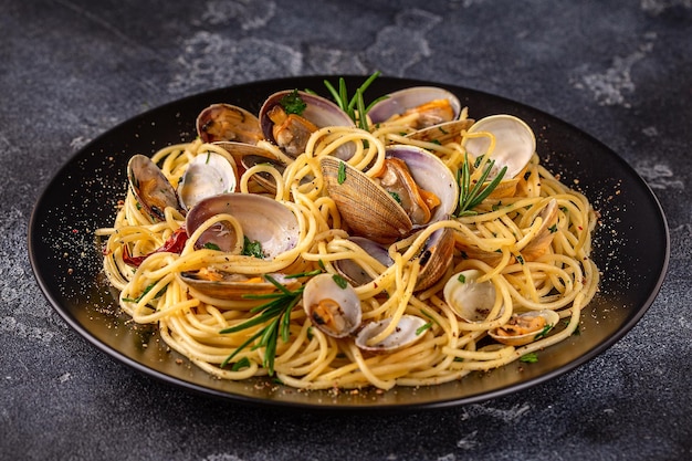 Zeevruchten pasta met venusschelpen Spaghetti alle Vongole op een donkere achtergrond