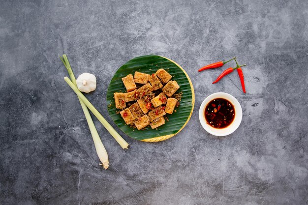 Zeevruchten Tofu met lente-ui knoflook vissaus geserveerd in kom geïsoleerd op donkergrijze achtergrond