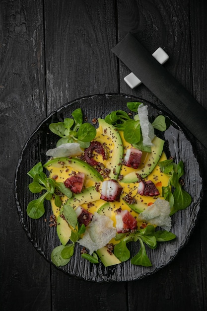 Zeevruchtensalade op een donkere plaat en een houten tafel