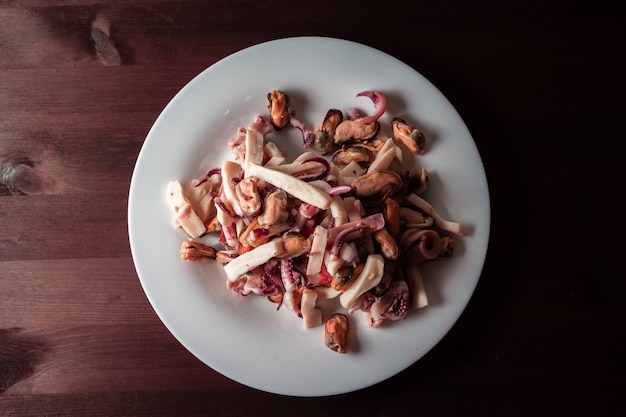 Zeevruchtensalade op een plaat op een houten lijst