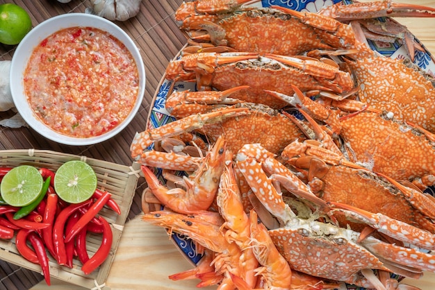 Zeevruchtenschotel gestoomde en gekookte blauwe krab geserveerd met Thaise pittige en zure dipsaus met zeevruchten