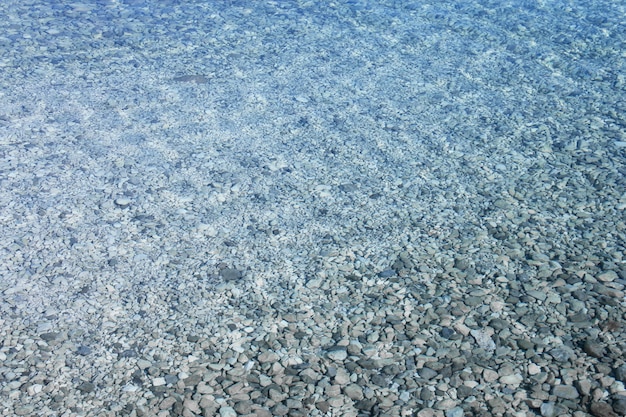 Zeewater in de buurt van strand natuurlijke achtergrond, wit stenen kiezelstrand in Kroatië Sumartin Brac eiland puur transparant mooi water