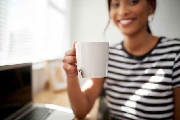 Zei iemand theetijd Bijgesneden opname van een onherkenbare vrouw die geniet van een kopje thee terwijl ze wakker wordt in haar studio