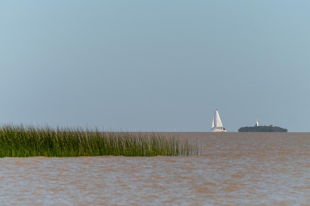 Zeilboot aan de horizon bij de rivier La Plata voor Colonia del Sacramento