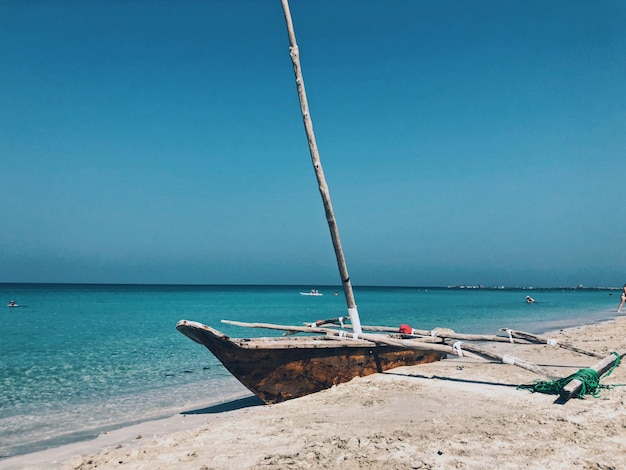 Foto zeilboot aan het strand tegen een heldere lucht