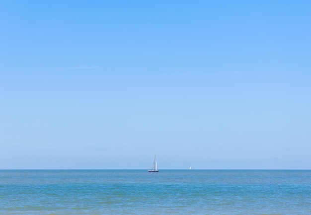 Zeilboot glijdt op helder oceaanwater tegen een zonnige hemel
