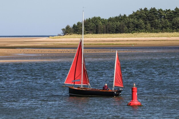 Foto zeilboot in het meer tegen de lucht