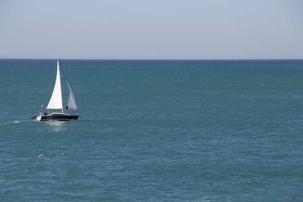 Zeilboot met witte zeilen zeilen in de zee