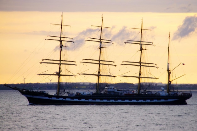 Foto zeilboot op zee bij zonsondergang