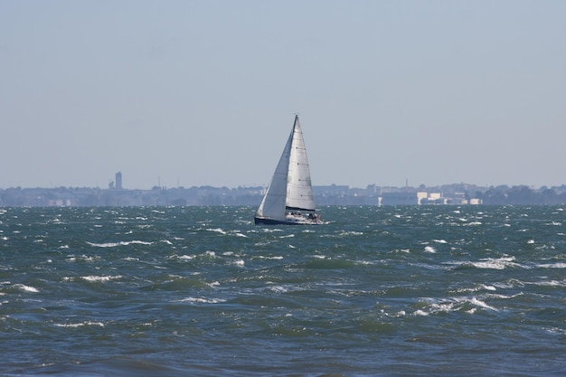 Zeilboot vaart bij grijs weer over de blauwe zee