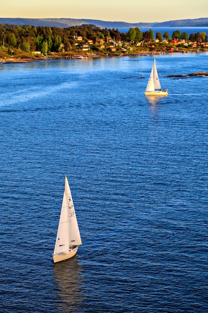 Zeilboot zeilen naar zonsondergang op een rustige avond