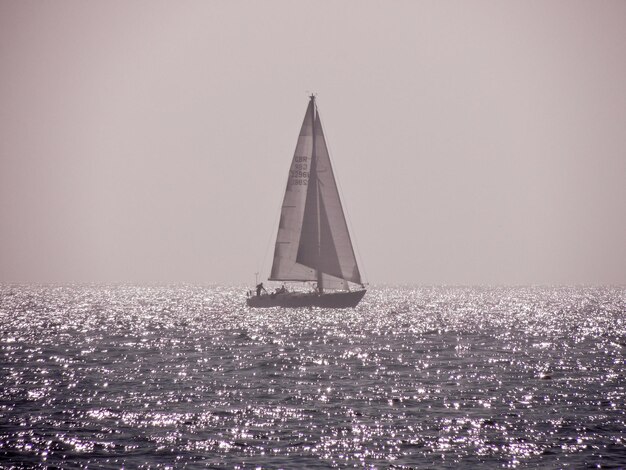 Foto zeilboot zeilt op zee tegen een heldere lucht