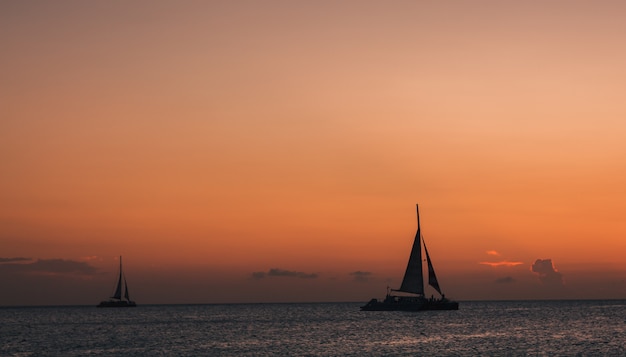 Foto zeilboten bij zonsondergang op zee landschap