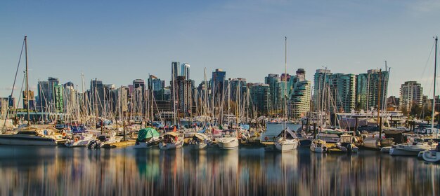 Foto zeilboten verankerd in de haven tegen de lucht in de stad