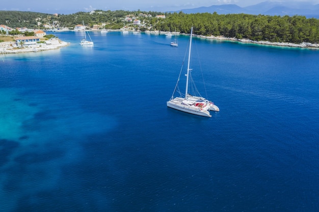 Zeiljachtboot in de blauwe zee arriveert in het dorp Fiscardo op het eiland Kefalonia, Griekenland