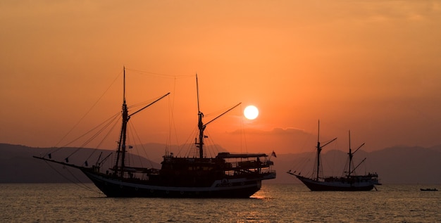 Zeilschip op zee bij zonsopgang (zonsondergang). Indonesië. Azië.