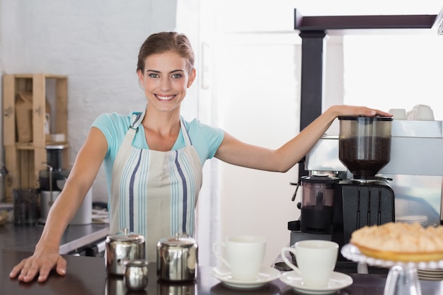 Zekere glimlachende barista die bij koffiewinkel voorbereidingen treffen