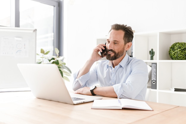 Zekere zakenman die op mobiele telefoon spreekt