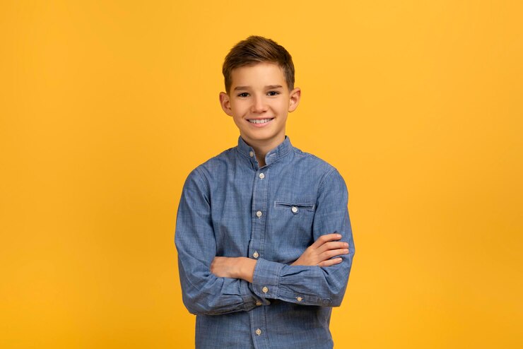 Foto zekerzinnige tiener jongen in blauw denim shirt met gekruiste armen