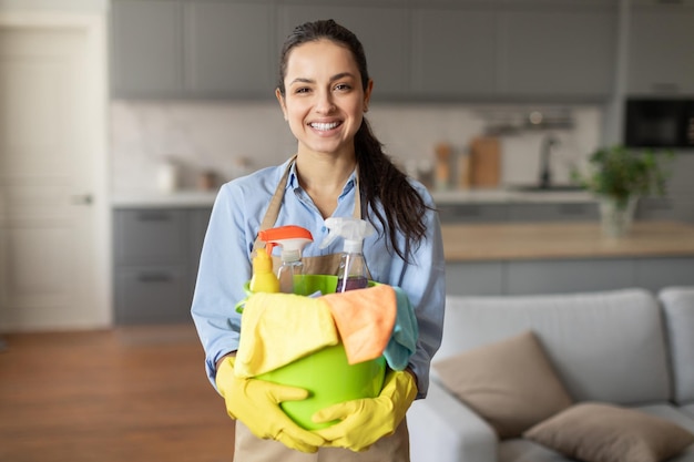 Zekerzinnige vrouw met een emmer schoonmaakmiddelen