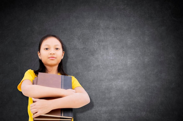 Zekerzinnige vrouwelijke student met boeken in de klas