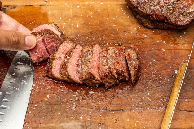 zeldzame picanha steak over natte snijplank op een barbecue concept scene