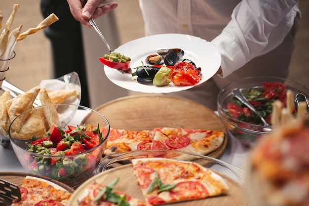 Zelfbediening aan het buffet. een verscheidenheid aan pizza's en salades.