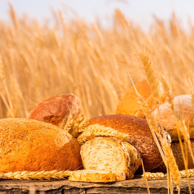 Zelfgebakken brood en tarwe op de houten tafel in herfst veld