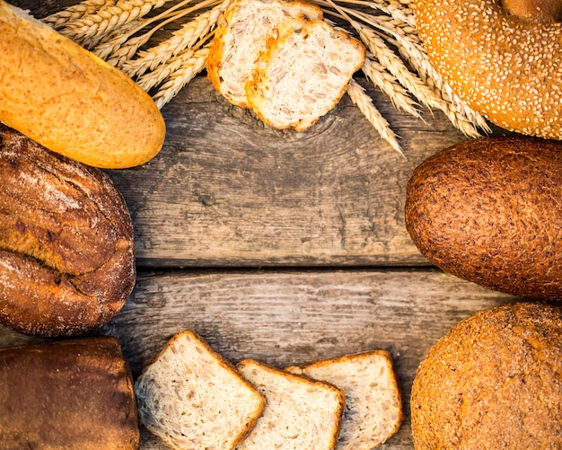 Zelfgebakken brood en tarwe op de houten tafel in herfst veld