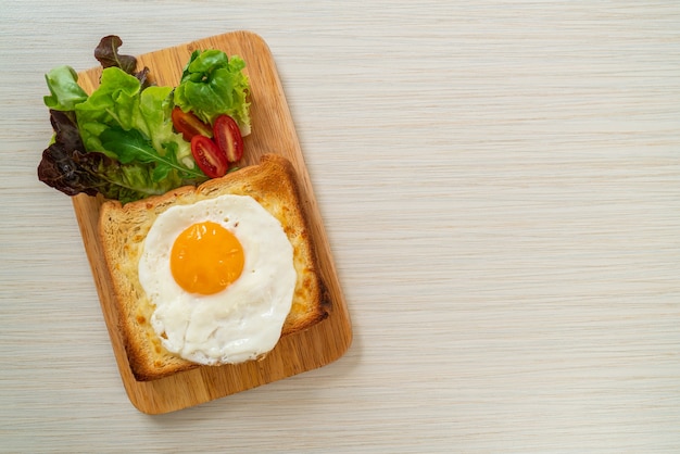 Zelfgebakken brood getoast met kaas en gebakken ei erop met groentesalade als ontbijt