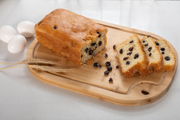 Zelfgebakken brood rozijnenbrood sneetje brood op een houten bord op witte achtergrond