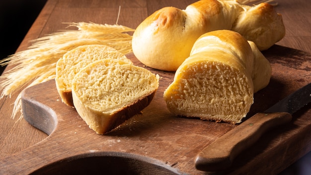 Zelfgebakken brood, twee mooie zelfgemaakte broden waarvan één op hout gesneden en een takje tarwe.