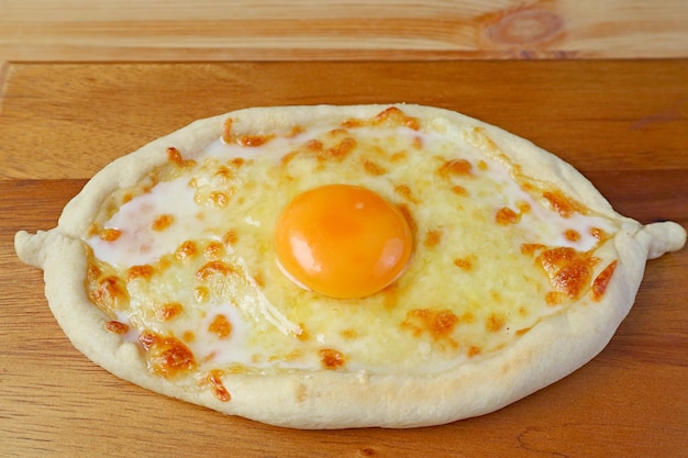 Zelfgemaakt adjarian khachapuri kaas en ei gevuld traditioneel georgisch brood