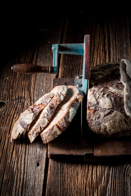 Zelfgemaakt brood op snijmachine op houten tafel