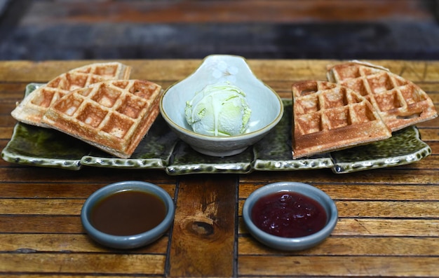 Zelfgemaakt ijs met chocoladesiroop en marmelade op houten ondergrond