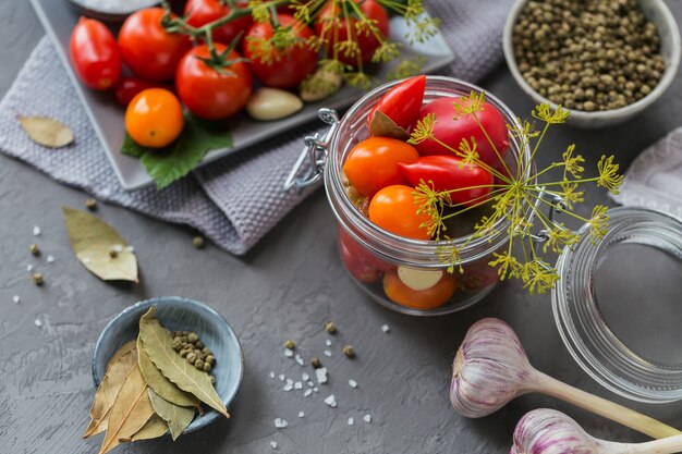 Foto zelfgemaakt inblikken. ingrediënt voor augurken tomaten met dille op de keukentafel.