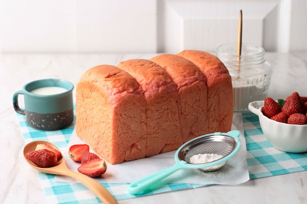 Zelfgemaakt roze sandwichbrood voor ontbijt, vers gebakken Japans zacht en pluizig broodje roze brood, populair als Hokkaido-melkbrood. Huisgemaakte Japanse Brioche