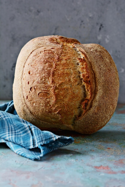Zelfgemaakt vers brood gemaakt van tarwe en volkoren meel op een grijze muur.