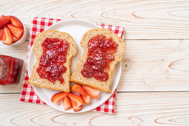 zelfgemaakt volkorenbrood met aardbeienjam en verse aardbeien